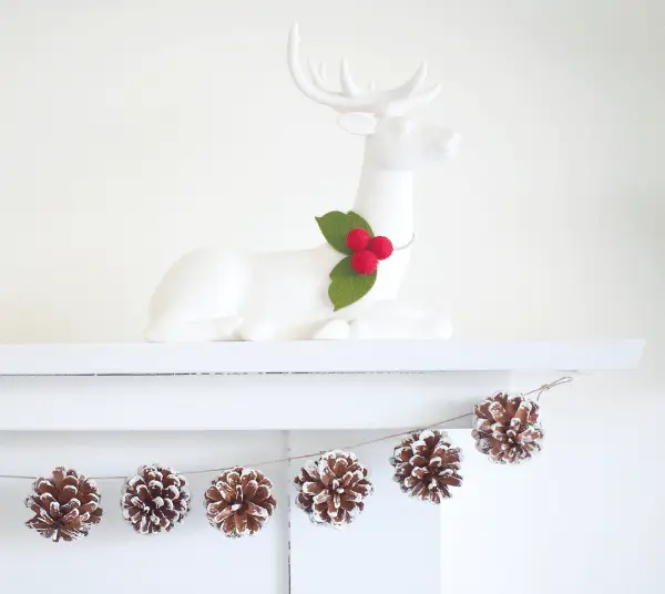 A wintry garland of pinecones painted white and tied with string, perfect for draping on a mantel as frosty DIY Christmas decorations.