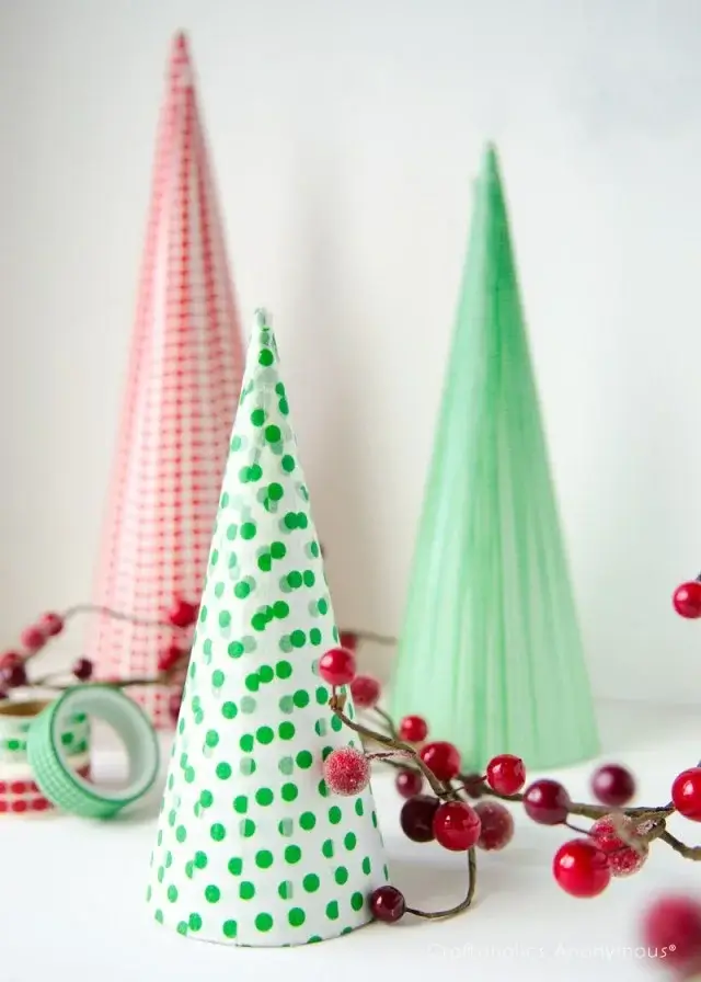 A minimalist apartment Christmas decor idea: a small tabletop tree made from a foam cone covered in red and white striped washi tape.