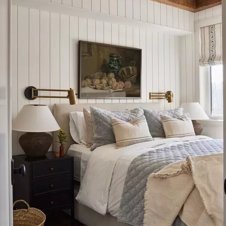 Dual lighting setup with sconces and ambient lighting in a couple’s bedroom.