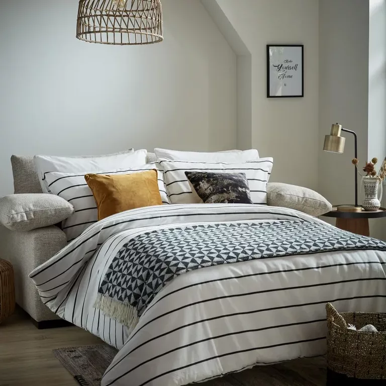 Modern sofa bed in a small couple's bedroom design.