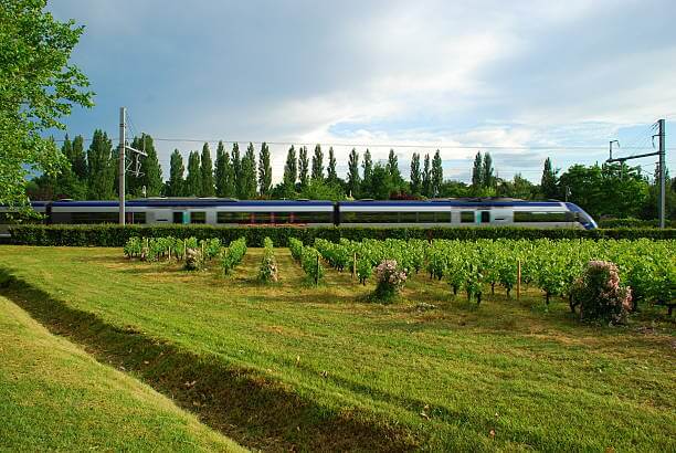 A regional TER train traveling through the scenic green French countryside, an ideal way to travel through France slowly.