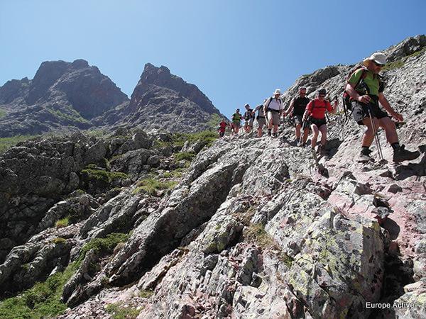 Hikers on the challenging GR20 trail, a ultimate slow travel experience with dramatic mountain scenery in Corsica