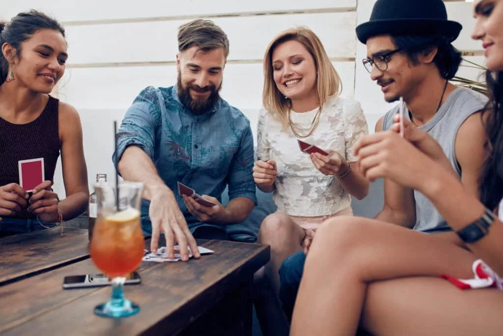 people play cards together at a dinner party