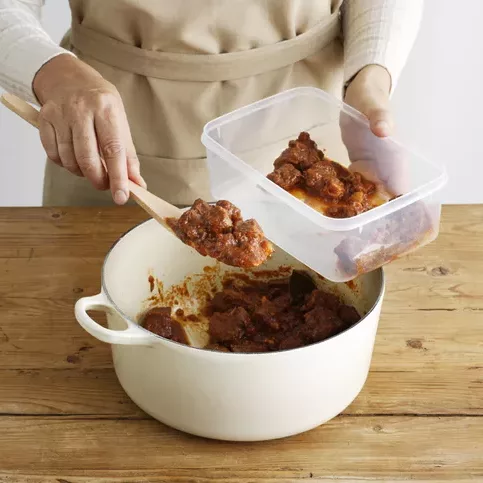 spooning leftovers into container