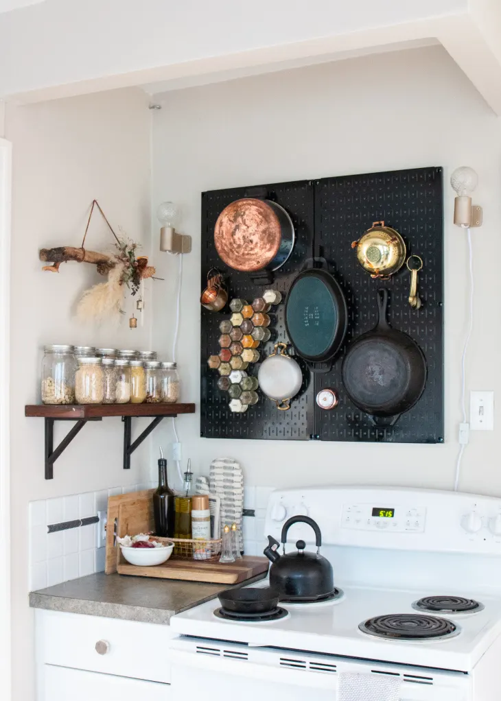 a small kitchen layout that used walls with a pegboard and shelves