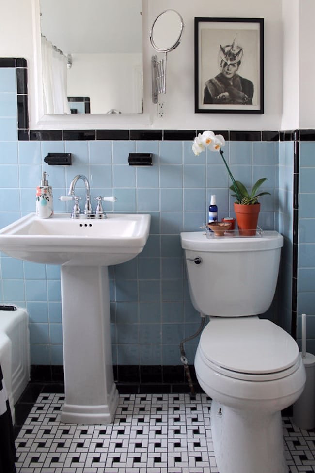 Funky bathroom with bold turquoise walls and retro bathroom decor accessories.