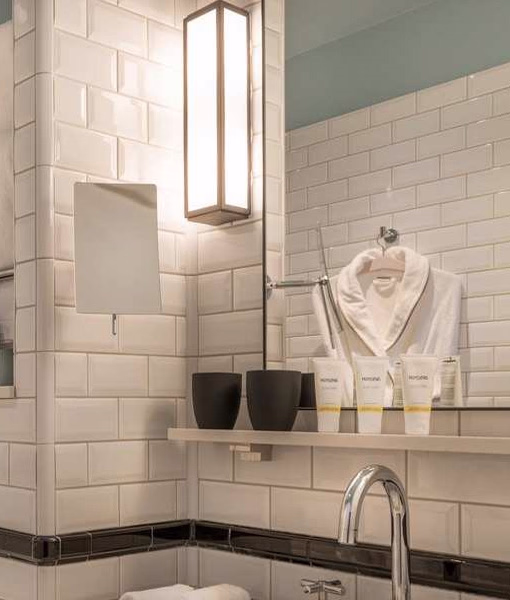 Retro bathroom design with subway tiles and art deco sconces for a chic, vintage vibe