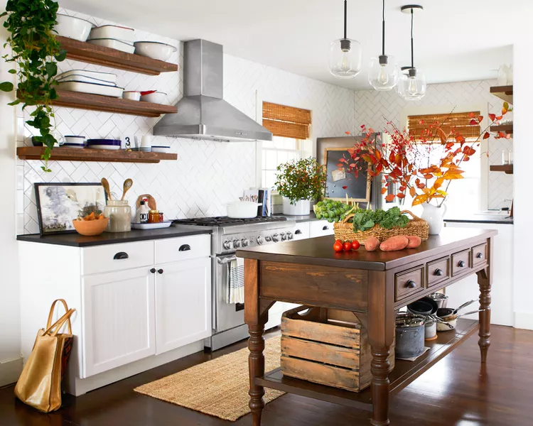 Dane Tashima

Open shelving in a rustic kitchen with vintage pans and natural finishes.