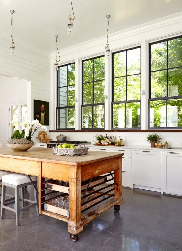 Rustic industrial wood kitchen island paired with natural stone flooring