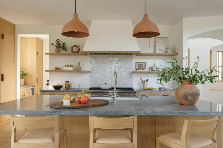 "Modern rustic kitchen showcasing open shelving and stone countertops."

