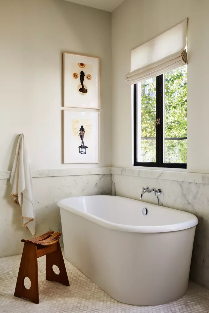 white and marble bathroom with framed art on the wall