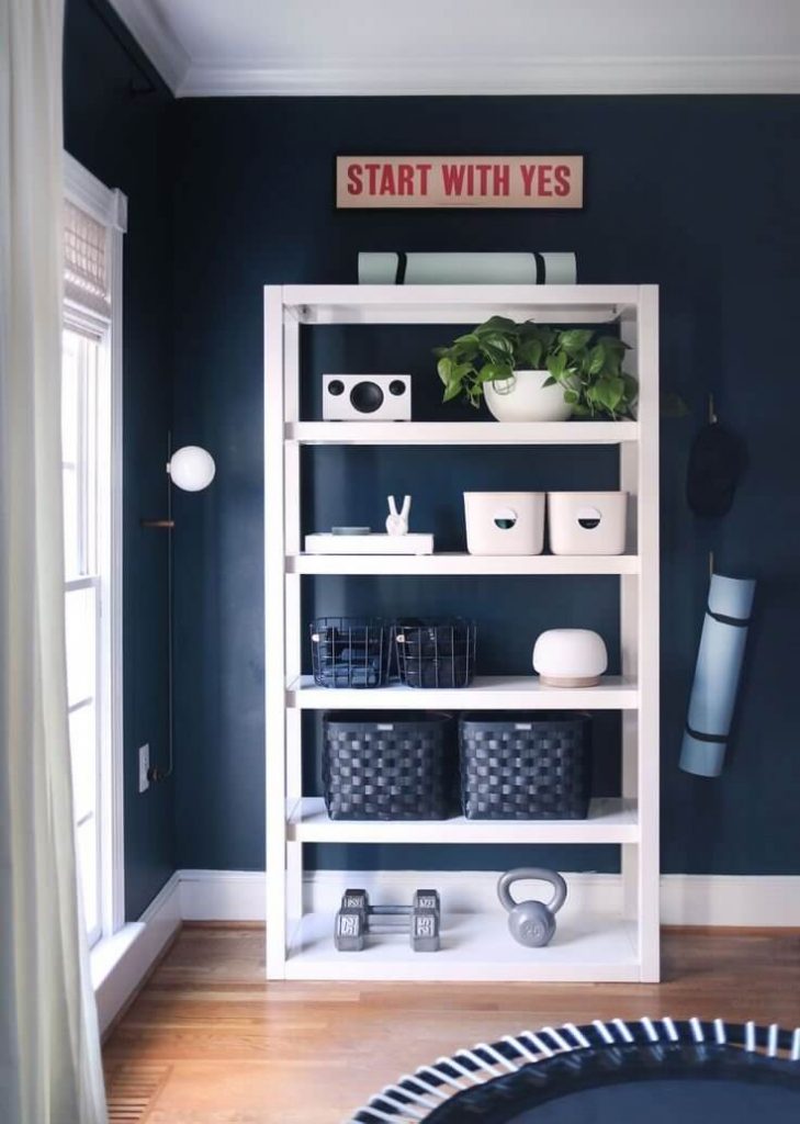 minimalist home gym essentials on a  bookshelf in a living room