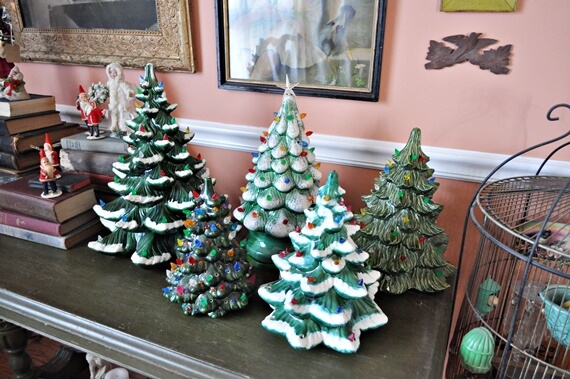 Old ceramic and plastic christmas trees on console table. 
