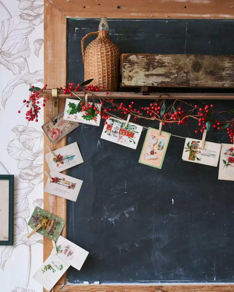  twine with vintage postcards pegged to it with tiny pegs. With pieces of holly and mistletoe added to it. Works in any style home from boho to modern.
