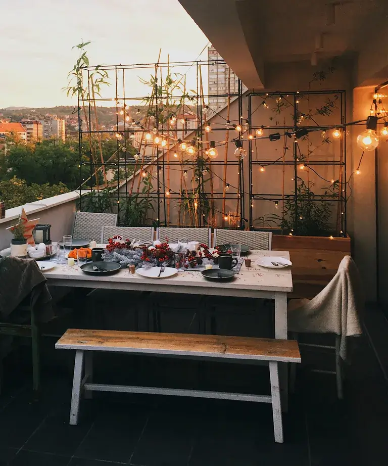 balcony dinner party lit up with string lights