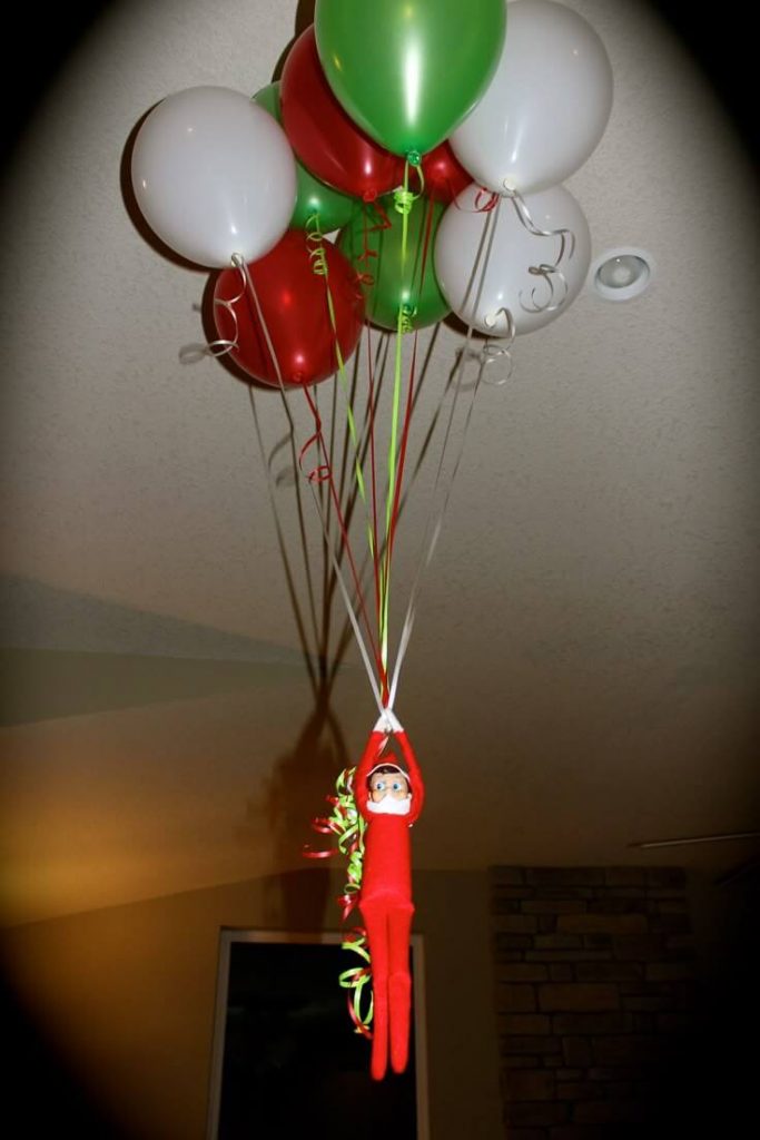 elf floating to the ceiling with ballons
