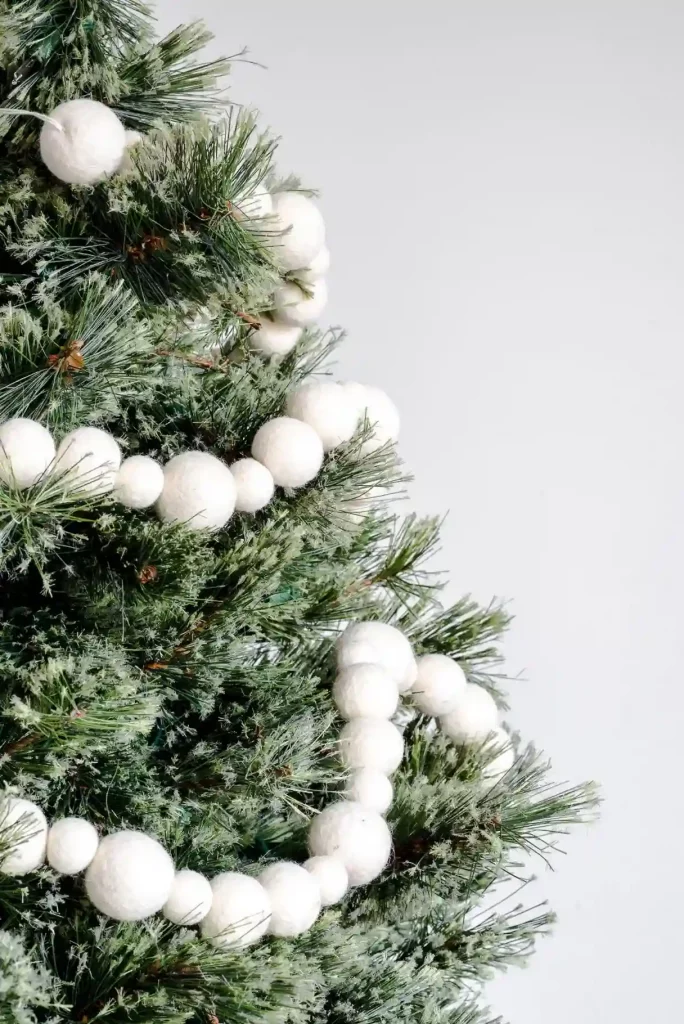  A DIY minimalist Christmas decoration with handmade paper stars and dried orange slices on a tree.