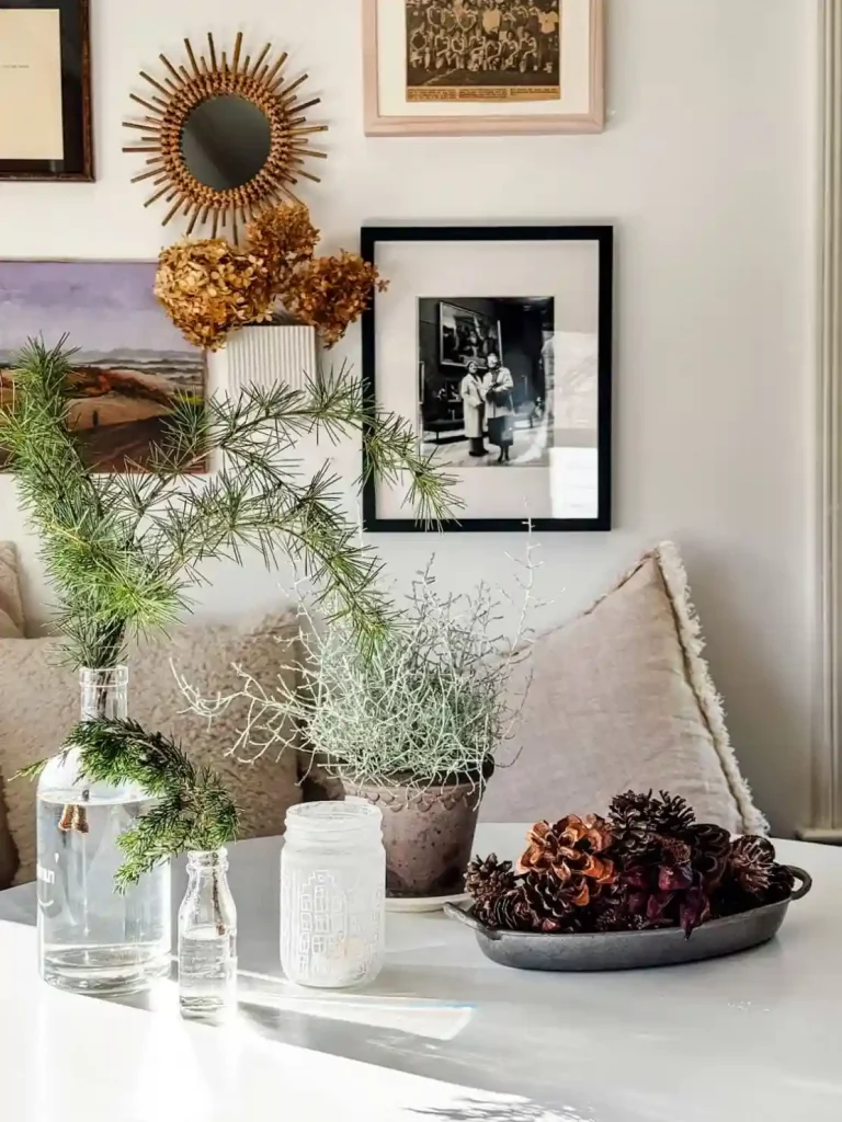 A tray filled with pinecones and a vase with a spruce sprig as simple Scandinavian Christmas decor.