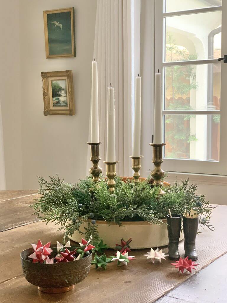 A traditional Scandinavian advent candle wreath on a wooden table in a scandi style home.