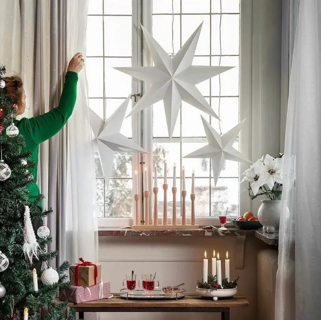 A classic paper julestjerne (Christmas star) hanging in a window as part of Scandinavian christmas decor.