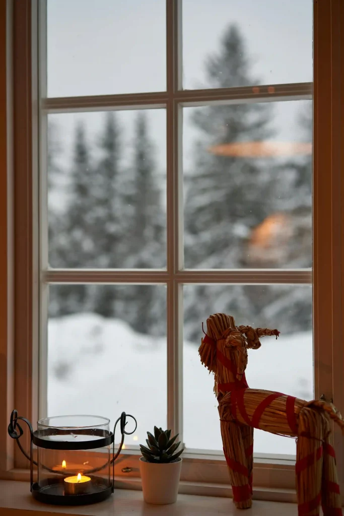 A traditional straw Yule goat displayed on a shelf in a modern holiday home.