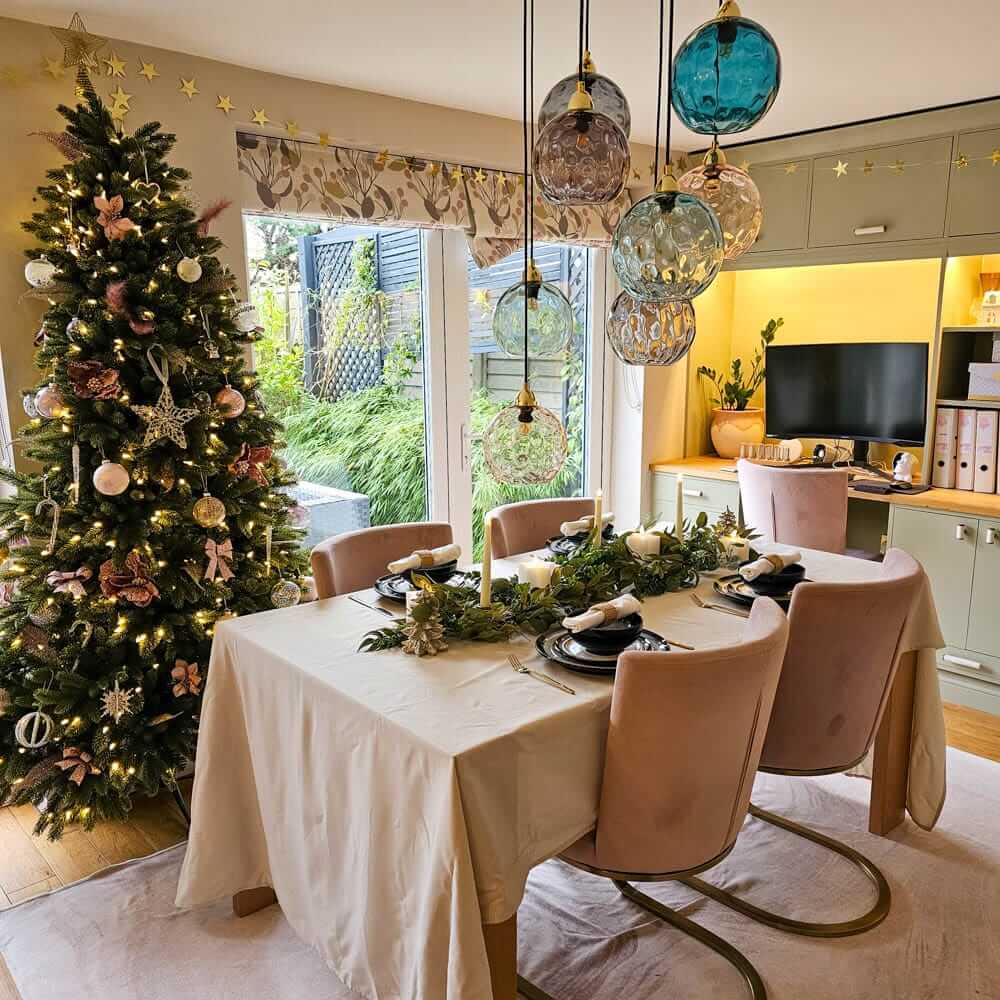 Simple apartment holiday table with a neutral tablecloth and slim garland centerpiece for a small-space Christmas celebration.