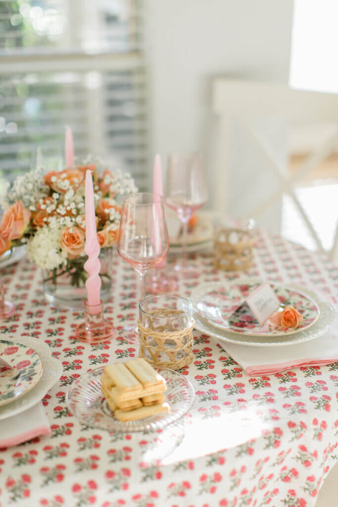 A festive Valentine's brunch table with a floral tablecloth and pastel candles for a small-space holiday table setting.