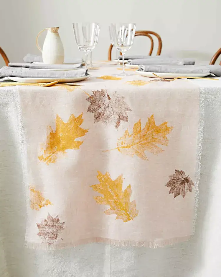  DIY leaf-print table runner creating a warm Thanksgiving table setting and natural fall table centerpiece for a small space.