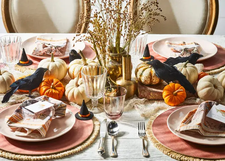 Simple Halloween tablescape mixing everyday dinnerware with mini pumpkins and witch hats for easy apartment holiday decor.
