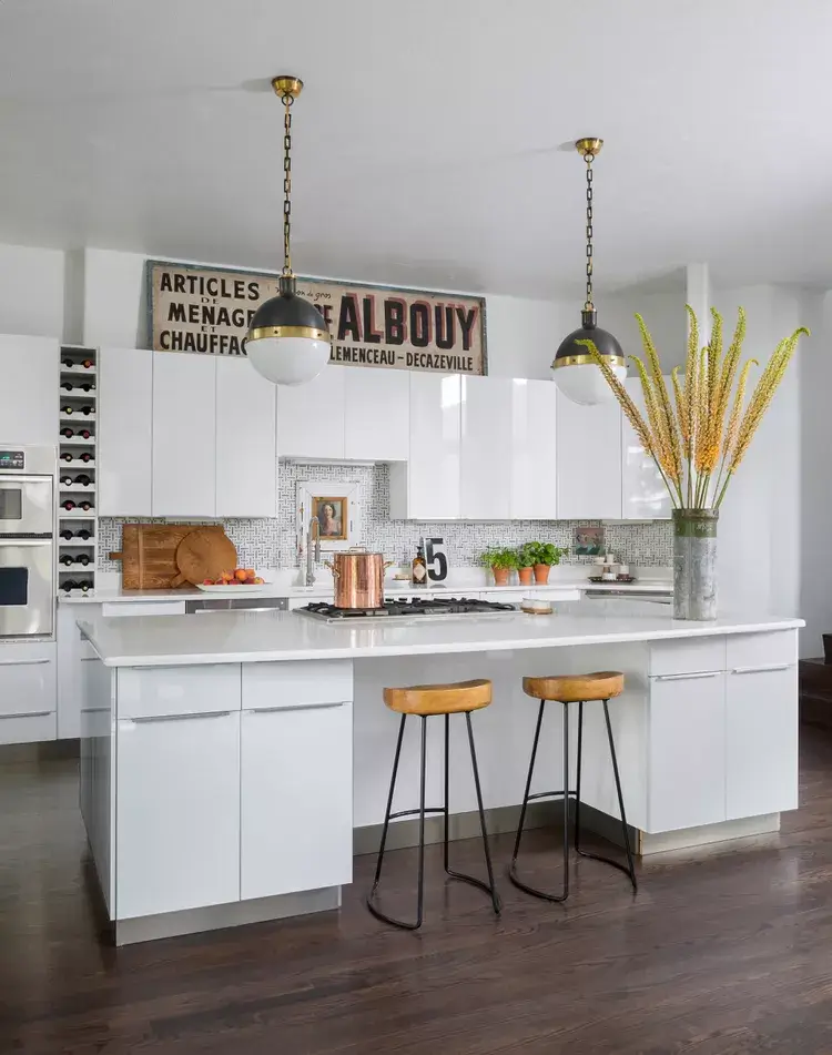 A large piece of leaning art is a modern answer for what to put on top of kitchen cabinets.