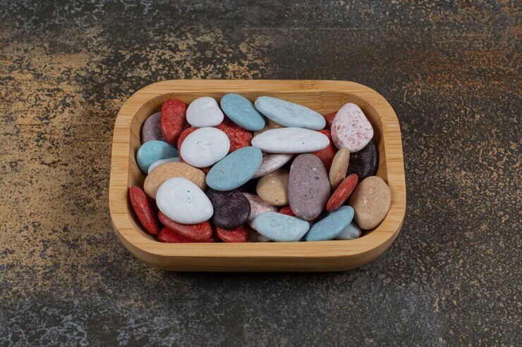 Minimalist trending interior designs showcase smooth river rocks displayed in a shallow wooden bowl.

