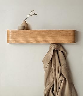 Wooden peg rail with narrow top shelf used as slim hallway furniture in a small entryway.