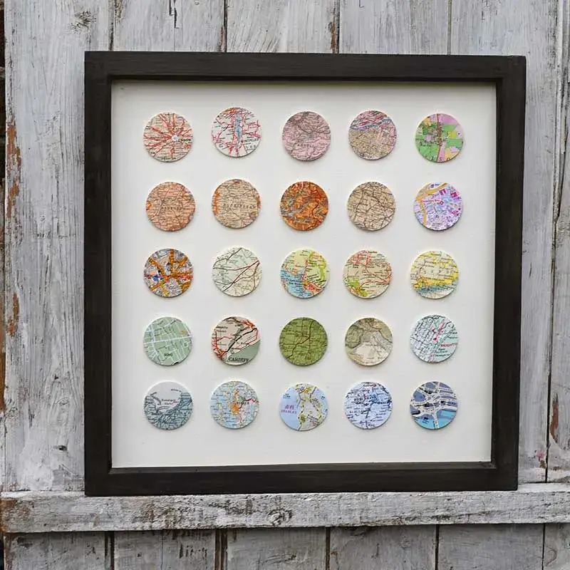 close-up shows a simple frame containing a carefully cut-out piece of a map highlighting a specific city