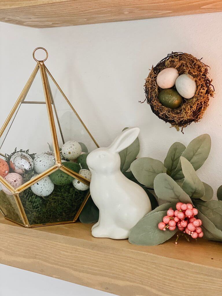 decorated eggs and faux moss in a terrarium