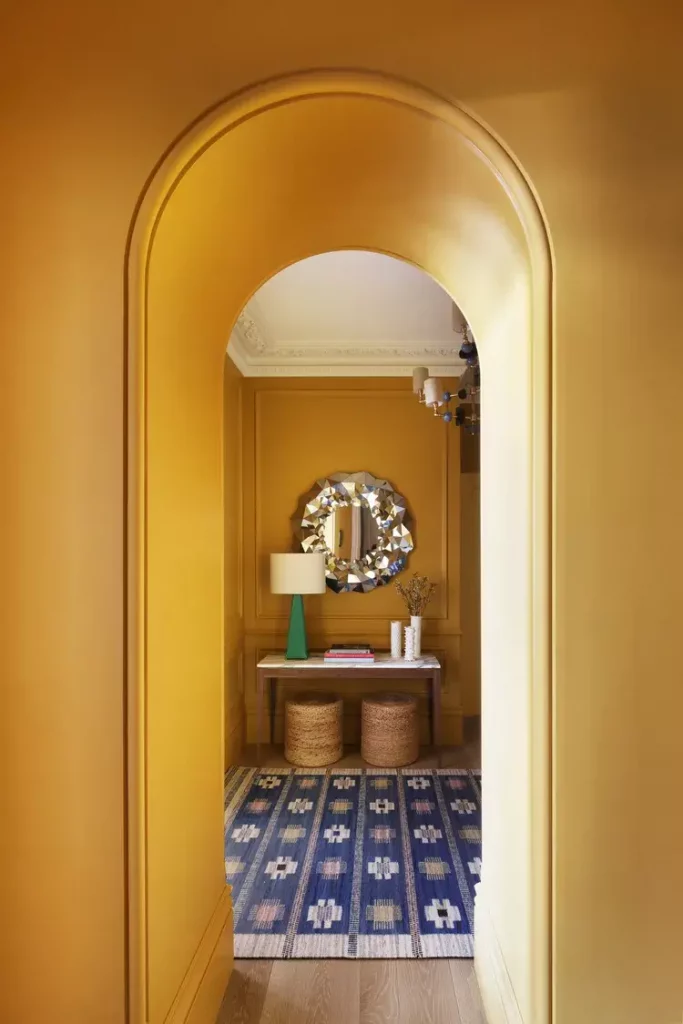 small home entrance in bold yellow with layered lighting