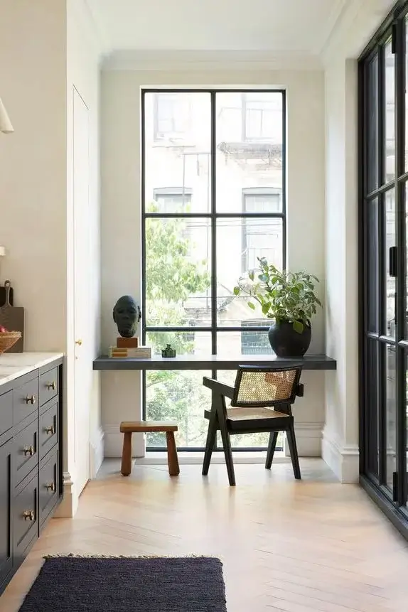 Small kitchen layout design with breakfast nook made with a floating table Infront of the window.