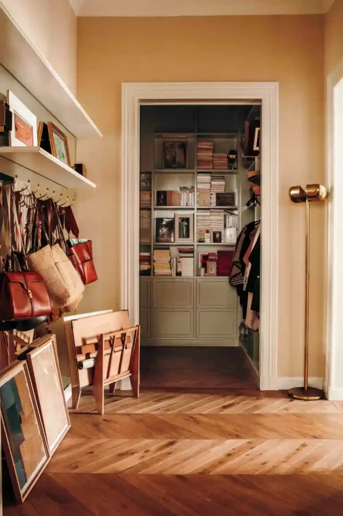 Homey apartment entryway with coats, books, artwork, and everyday essentials creating practical apartment decorating inspiration.