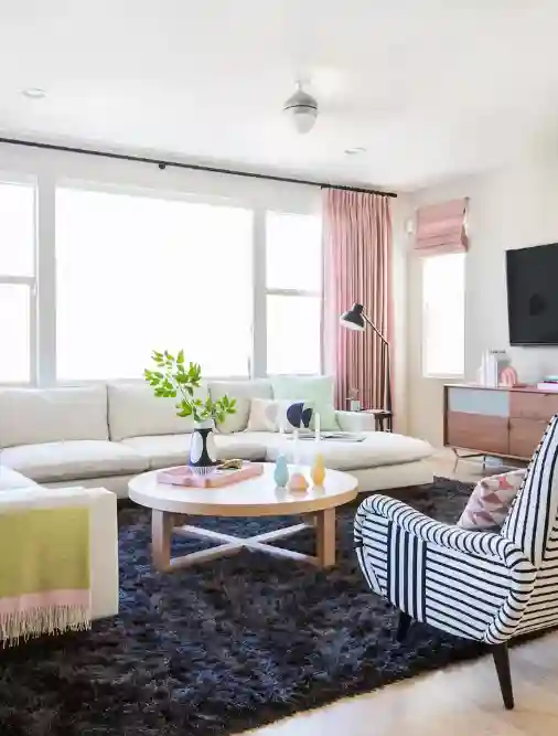 Apartment decorating featuring pastel pink accents, a shag rug, and minimalist furniture for a cozy apartment style.