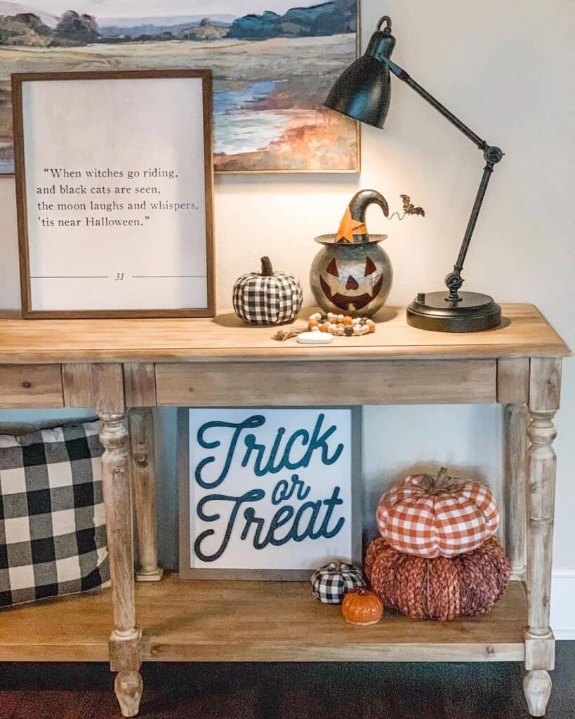 Small apartment entryway with simple Halloween decorations on a narrow console.