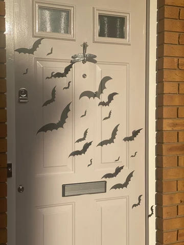 Paper bats arranged on the front door for renter-friendly Halloween decor.