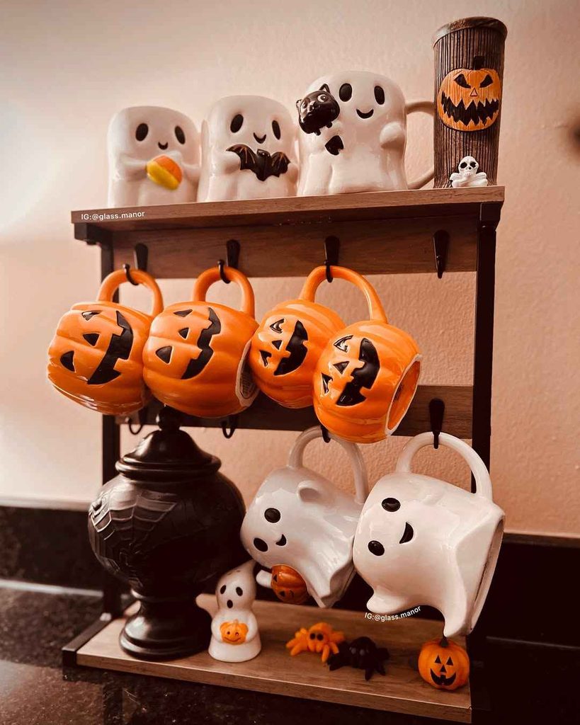 Small kitchen counter decorated Halloween mugs and simple Halloween accessories.