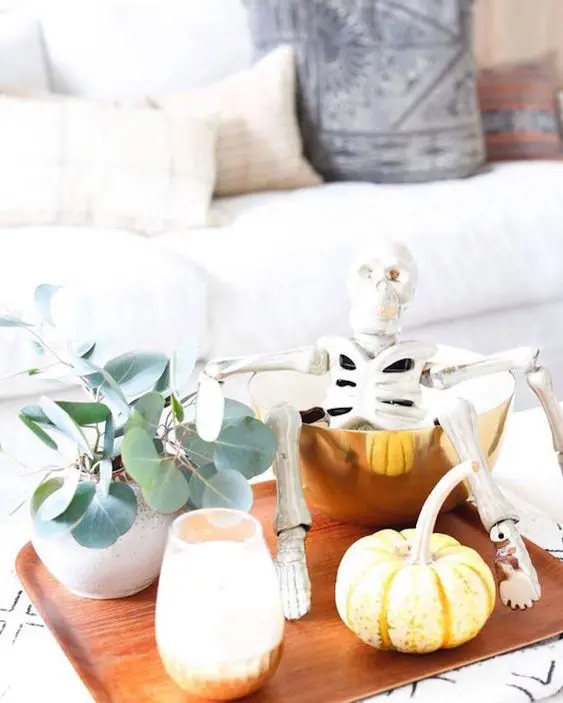 Renter friendly Halloween decor styled on a tray places on an ottoman in the living room.