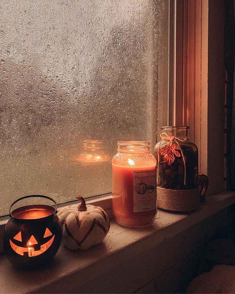 Apartment windowsill decorated with miniature pumpkins for Halloween.