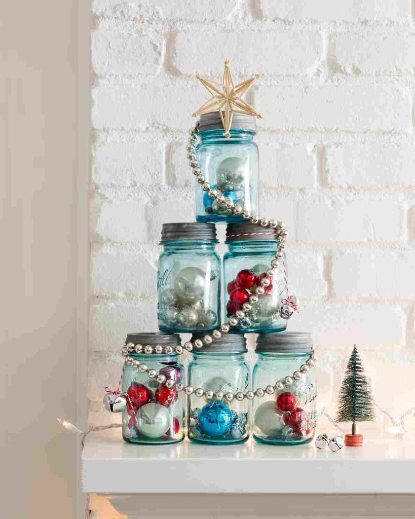 Blue glass jars filled with Christmas ornaments stacked into a Christmas tree shape