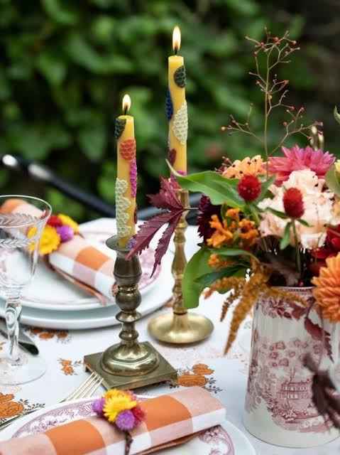 Minimal Thanksgiving place setting with white plate, taper candle, and simple but bold candleholder