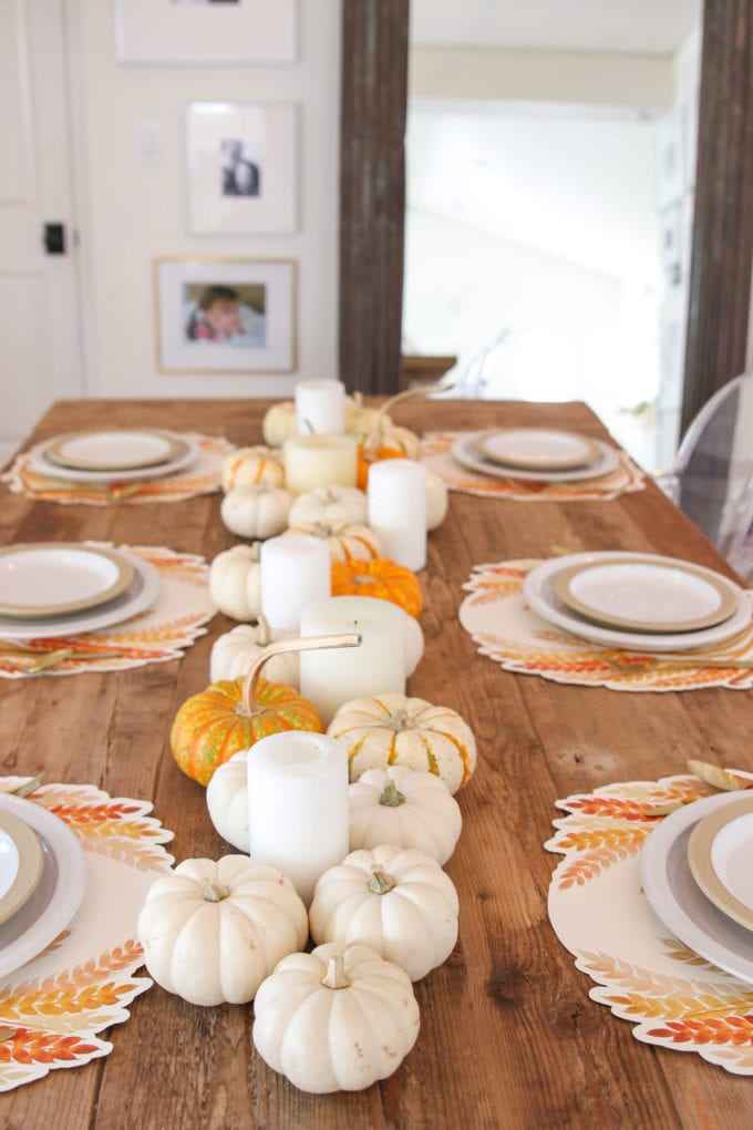 Mini pumpkins arranged along a dining table as simple fall table decor
